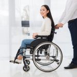 close-up-businessman-pushing-disabled-woman-sitting-wheelchair_23-2148127382
